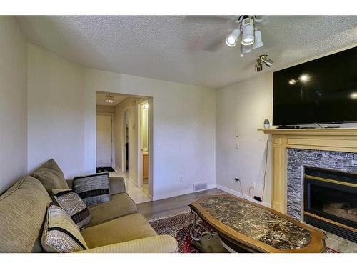 250 Coral Keys Court Ne, Calgary, AB - Indoor Photo Showing Living Room With Fireplace