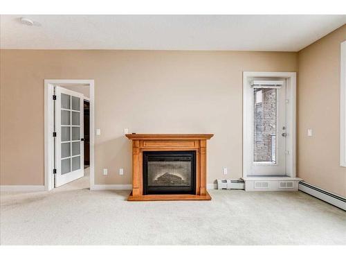 311-35 Aspenmont Heights Sw, Calgary, AB - Indoor Photo Showing Living Room With Fireplace