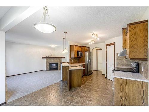 48 Eversyde Manor Sw, Calgary, AB - Indoor Photo Showing Kitchen With Fireplace