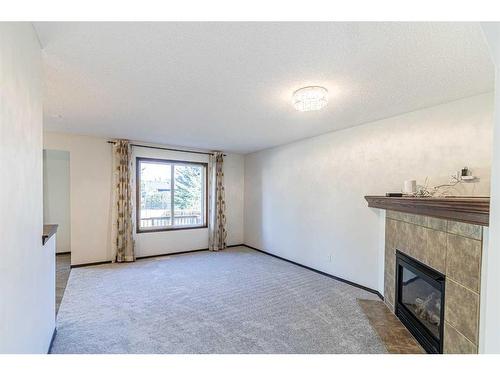 48 Eversyde Manor Sw, Calgary, AB - Indoor Photo Showing Other Room With Fireplace