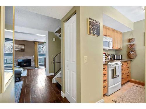 703-2520 Palliser Drive Sw, Calgary, AB - Indoor Photo Showing Kitchen With Fireplace