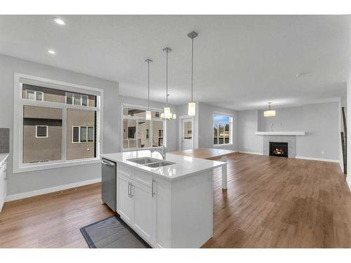 109 Kinniburgh Cove, Chestermere, AB - Indoor Photo Showing Kitchen With Fireplace With Double Sink