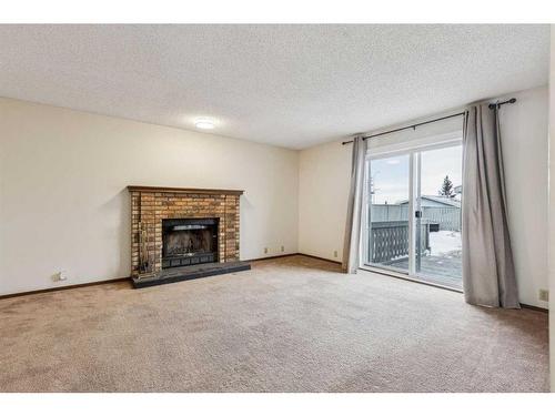 51 Sandstone Rise Nw, Calgary, AB - Indoor Photo Showing Living Room With Fireplace