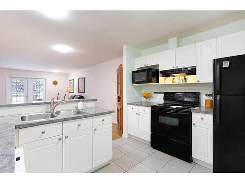 5-103 Fairways Drive Nw, Airdrie, AB - Indoor Photo Showing Kitchen With Double Sink