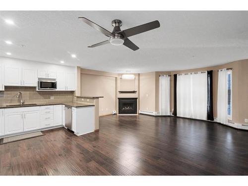 210-8535 Bonaventure Drive Se, Calgary, AB - Indoor Photo Showing Kitchen With Fireplace