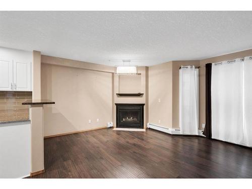 210-8535 Bonaventure Drive Se, Calgary, AB - Indoor Photo Showing Living Room With Fireplace