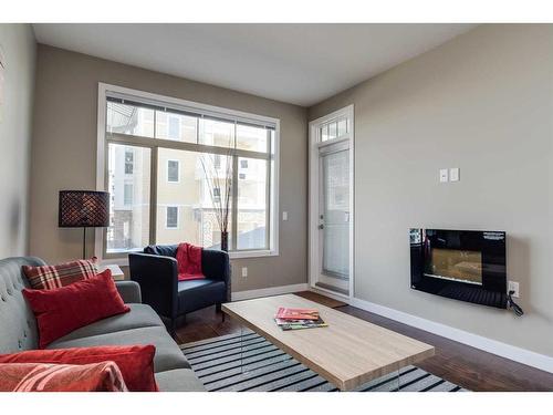 205-22 Auburn Bay Link Se, Calgary, AB - Indoor Photo Showing Living Room With Fireplace