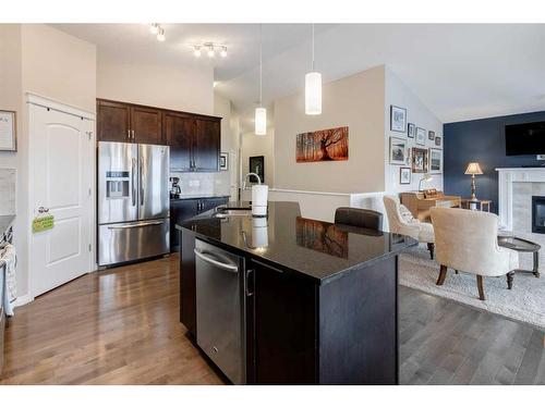 28 Jumping Pound Rise, Cochrane, AB - Indoor Photo Showing Kitchen With Fireplace