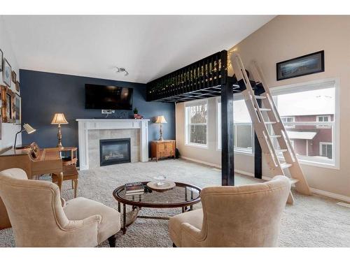 28 Jumping Pound Rise, Cochrane, AB - Indoor Photo Showing Living Room With Fireplace