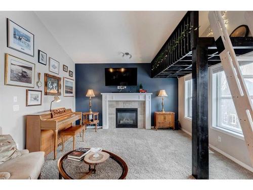 28 Jumping Pound Rise, Cochrane, AB - Indoor Photo Showing Living Room With Fireplace