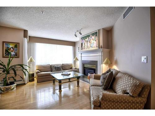 211-9449 19 Street Sw, Calgary, AB - Indoor Photo Showing Living Room With Fireplace