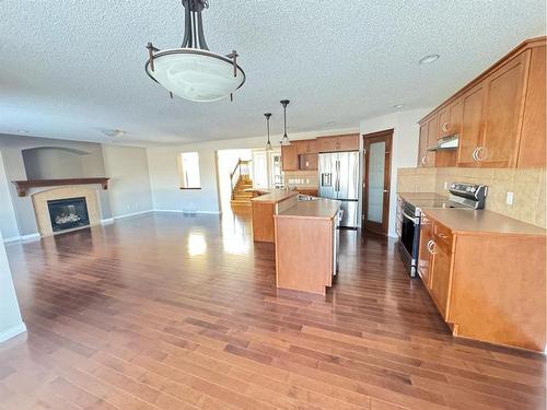 23 Chapman Green Se, Calgary, AB - Indoor Photo Showing Kitchen With Fireplace