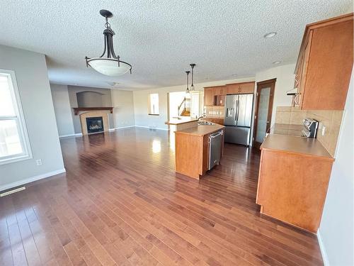 23 Chapman Green Se, Calgary, AB - Indoor Photo Showing Kitchen With Fireplace