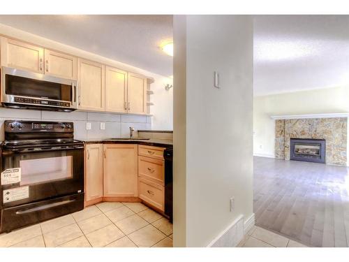 174-77 Glamis Green Sw, Calgary, AB - Indoor Photo Showing Kitchen With Fireplace