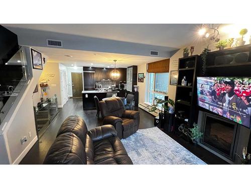 102-99 Spruce Place Sw, Calgary, AB - Indoor Photo Showing Living Room With Fireplace