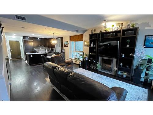 102-99 Spruce Place Sw, Calgary, AB - Indoor Photo Showing Living Room With Fireplace