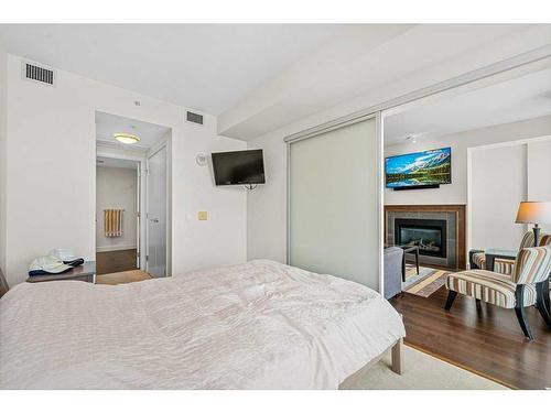 812-222 Riverfront Avenue Sw, Calgary, AB - Indoor Photo Showing Bedroom With Fireplace