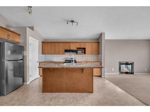 250 Martinwood Place Ne, Calgary, AB - Indoor Photo Showing Kitchen With Fireplace