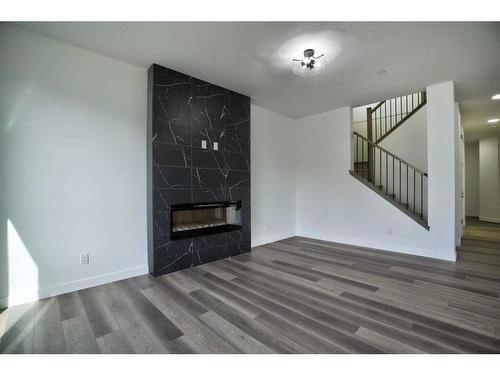 87 Hotchkiss Manor Se, Calgary, AB - Indoor Photo Showing Other Room With Fireplace