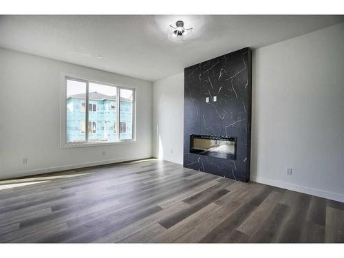 87 Hotchkiss Manor Se, Calgary, AB - Indoor Photo Showing Other Room With Fireplace