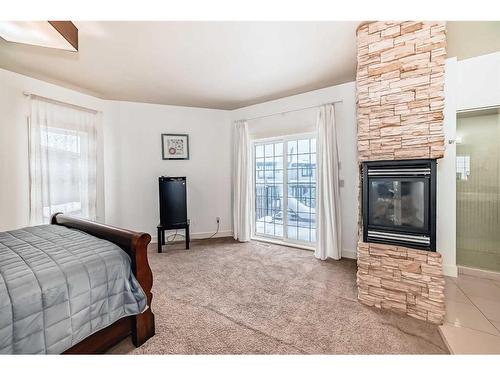 16 Rockcliff Point Nw, Calgary, AB - Indoor Photo Showing Bedroom With Fireplace