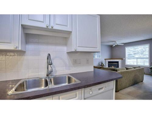 144 Mt Aberdeen Manor Se, Calgary, AB - Indoor Photo Showing Kitchen With Fireplace With Double Sink