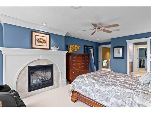 22 Strathridge Grove Sw, Calgary, AB - Indoor Photo Showing Bedroom With Fireplace