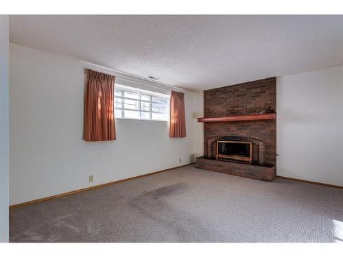 6119 Thornaby Way Nw, Calgary, AB - Indoor Photo Showing Living Room With Fireplace