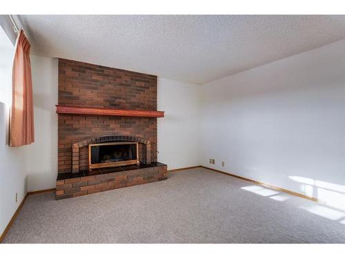 6119 Thornaby Way Nw, Calgary, AB - Indoor Photo Showing Living Room With Fireplace