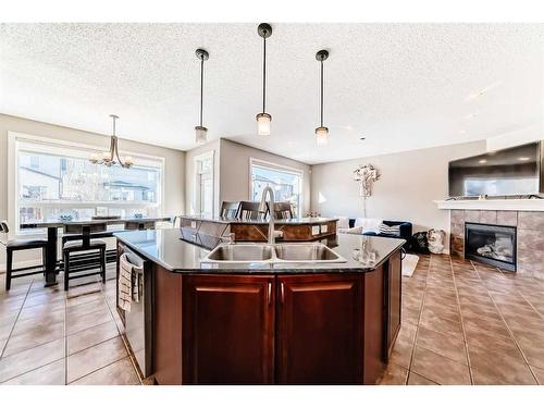 153 Chapalina Heights Se, Calgary, AB - Indoor Photo Showing Kitchen With Fireplace With Double Sink