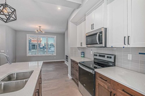 23 Agate Road, Cochrane, AB - Indoor Photo Showing Kitchen With Double Sink With Upgraded Kitchen