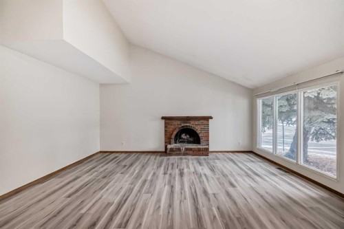652 Queensland Drive Se, Calgary, AB - Indoor Photo Showing Living Room With Fireplace