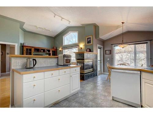 4 Evergreen Way Sw, Calgary, AB - Indoor Photo Showing Kitchen With Fireplace