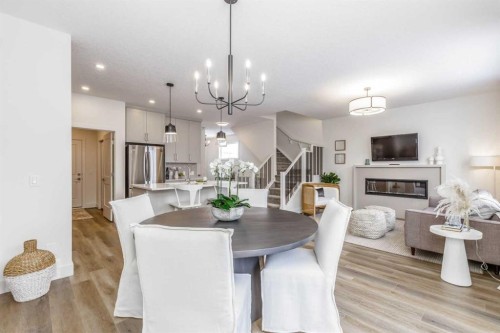 84 Emberside Green, Cochrane, AB - Indoor Photo Showing Dining Room With Fireplace