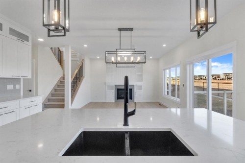 14 Ranchers Meadows, Okotoks, AB - Indoor Photo Showing Kitchen With Fireplace With Double Sink