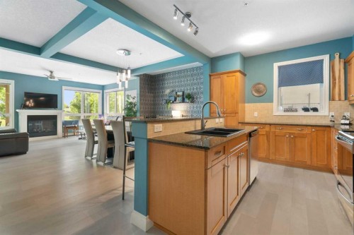 2110-10221 Tuscany Boulevard Nw, Calgary, AB - Indoor Photo Showing Kitchen With Fireplace With Double Sink