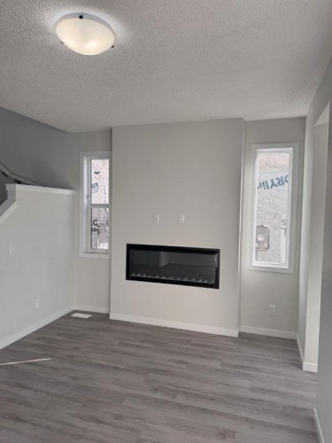 113 Setonvista Gate Se, Calgary, AB - Indoor Photo Showing Living Room With Fireplace