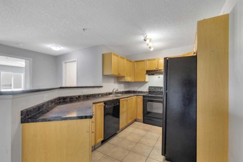 6307-304 Mackenzie Way Sw, Airdrie, AB - Indoor Photo Showing Kitchen With Double Sink