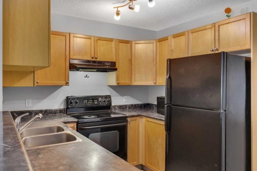 6307-304 Mackenzie Way Sw, Airdrie, AB - Indoor Photo Showing Kitchen With Double Sink