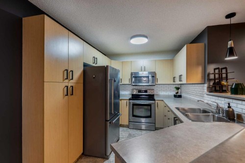 8213-304 Mackenzie Way Sw, Airdrie, AB - Indoor Photo Showing Kitchen With Double Sink