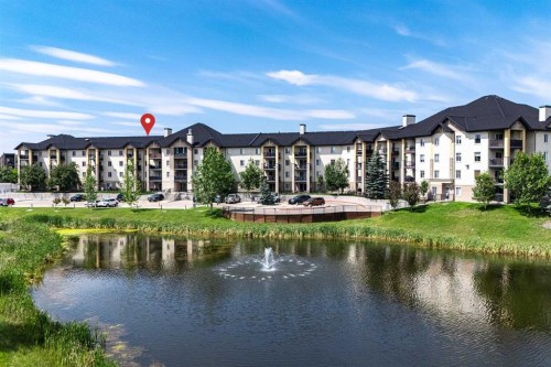 8213-304 Mackenzie Way Sw, Airdrie, AB - Outdoor With Body Of Water With Facade
