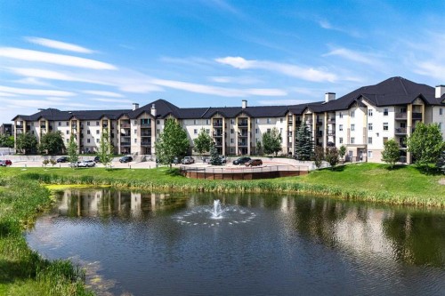 8213-304 Mackenzie Way Sw, Airdrie, AB - Outdoor With Body Of Water With Facade