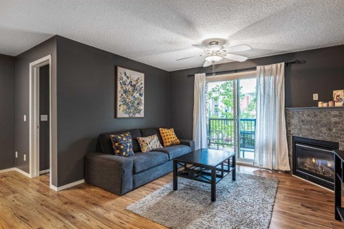 8213-304 Mackenzie Way Sw, Airdrie, AB - Indoor Photo Showing Living Room With Fireplace