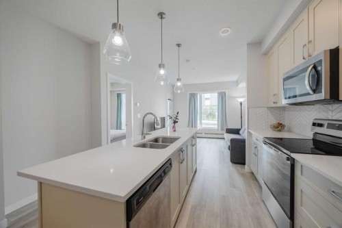 102-200 Shawnee Square Sw, Calgary, AB - Indoor Photo Showing Kitchen With Stainless Steel Kitchen With Double Sink With Upgraded Kitchen