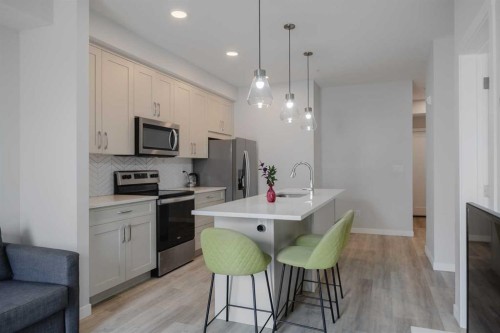 102-200 Shawnee Square Sw, Calgary, AB - Indoor Photo Showing Kitchen With Stainless Steel Kitchen With Upgraded Kitchen