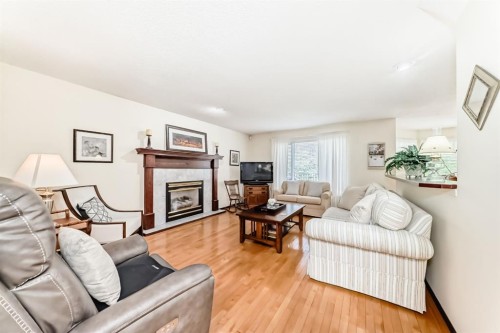 83 Gleneagles Close, Cochrane, AB - Indoor Photo Showing Living Room With Fireplace