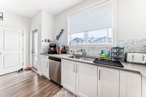 1703 Jumping Pound Common, Cochrane, AB - Indoor Photo Showing Kitchen With Double Sink