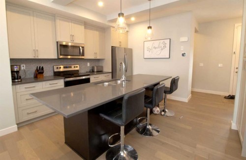 103 Sunrise Common, Cochrane, AB - Indoor Photo Showing Kitchen With Double Sink With Upgraded Kitchen