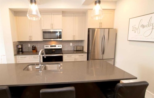 103 Sunrise Common, Cochrane, AB - Indoor Photo Showing Kitchen With Double Sink With Upgraded Kitchen