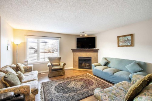 15 Kingsland Way Se, Airdrie, AB - Indoor Photo Showing Living Room With Fireplace